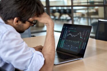 Stressed business man crypto trader broker investor analyzing stock exchange market crypto trading decreasing chart data fall down loss, desperate about losing money of crisis, recession, inflation.
