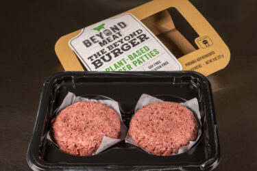 Packagingand contents of Beyond Meat Beyond Burgers on steel background